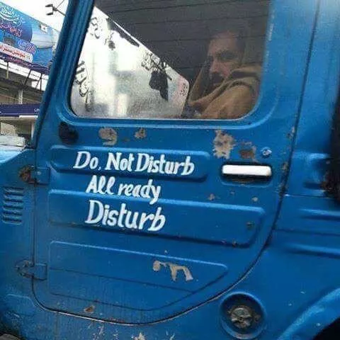 there&rsquo;s a man in the passenger seat looking pissed off and on the door next to him, hand painted words say &lsquo;do not disturb, all ready disturb&rsquo;