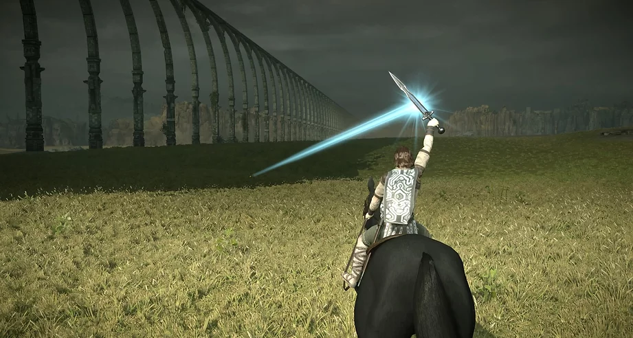 Wander is on horse back on a field below the massive bridge and holding a sword above his head that is shooting out a huge blue stream of light to direct the player to the next Colossus