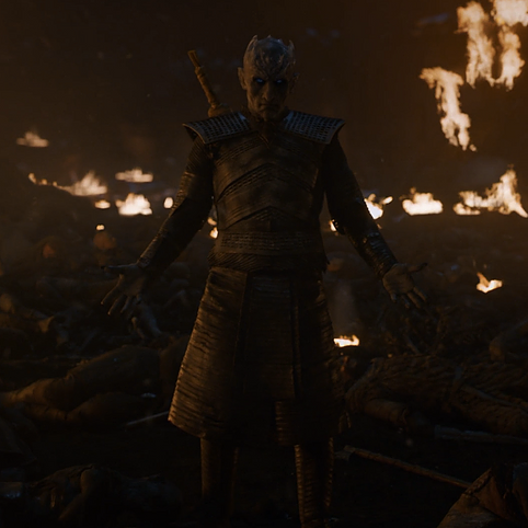 the night king stands with his arms at his sides in front of a burning village