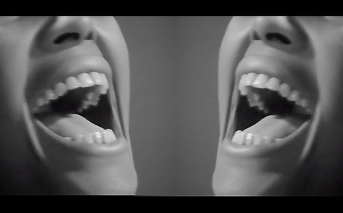 a black and white image of a mouth open wide and smiling but it&rsquo;s doubled up and symmetrical
