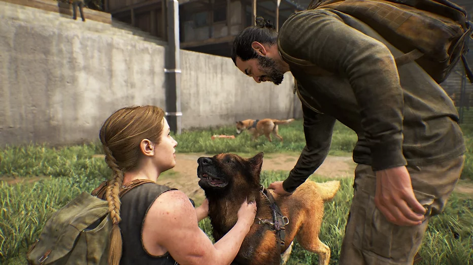 Two people stand bending down to stroke a german shepherd who is smiling