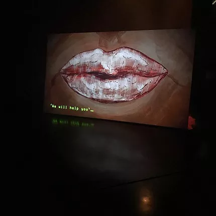 A projection of an illustration shows a mouth saying &lsquo;we will help you&rsquo;