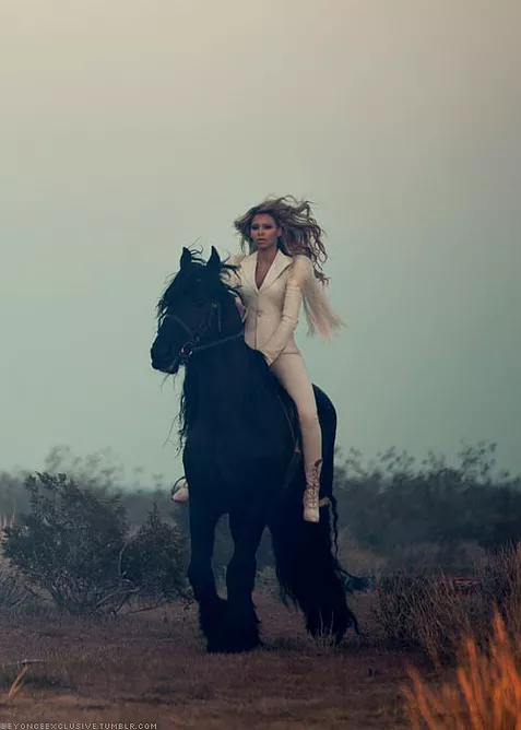 beyonce in a white suit on a completely black horse in the middle of nowhere
