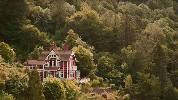 the amazing huge red house in sex education that Otis lives in against an amazing forest
