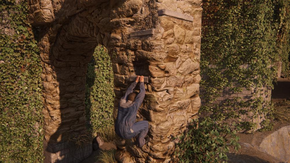 a man in blue overalls hangs off a small ledge as he navigates an old archy somewhere in Italy, lovely ivy covering the walls behind, and yet again, there just so happen to be a few smooth ledges that he's able to jump between in the perfect places