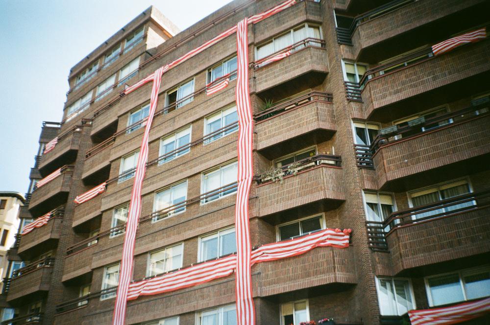 red and white striped material draped down and across a building like a ribbon around a present