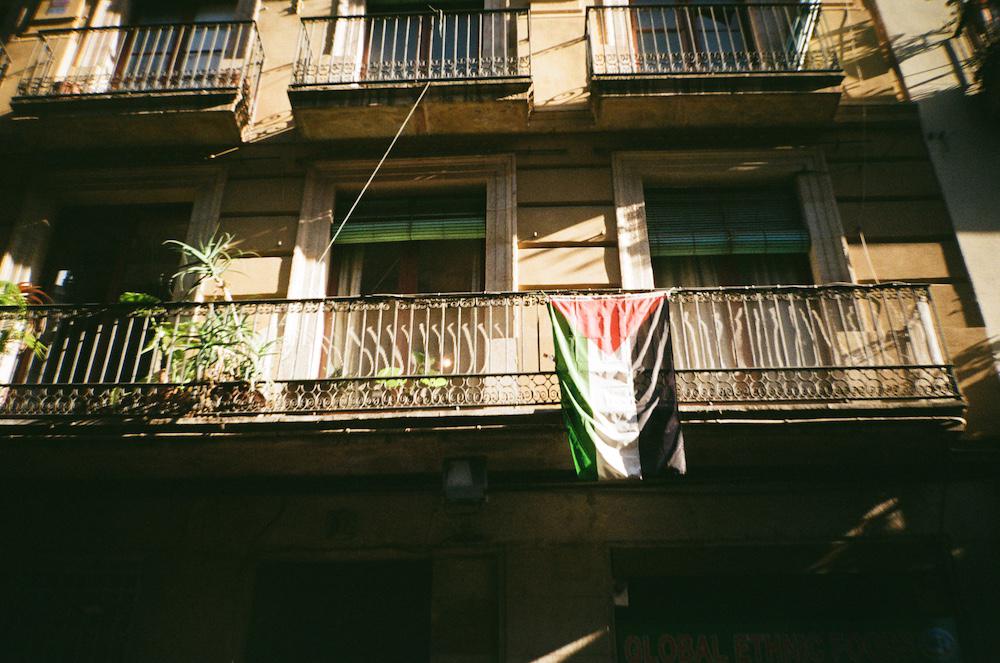 a palestinian flag draped over a balcony in Barcelona