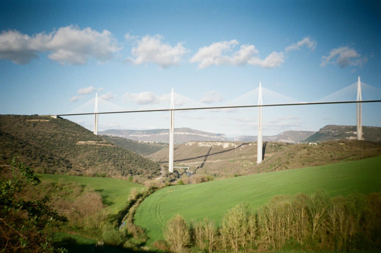 norman foster's millau viaduct, a big white bridge casting a shadow down onto the ground below it