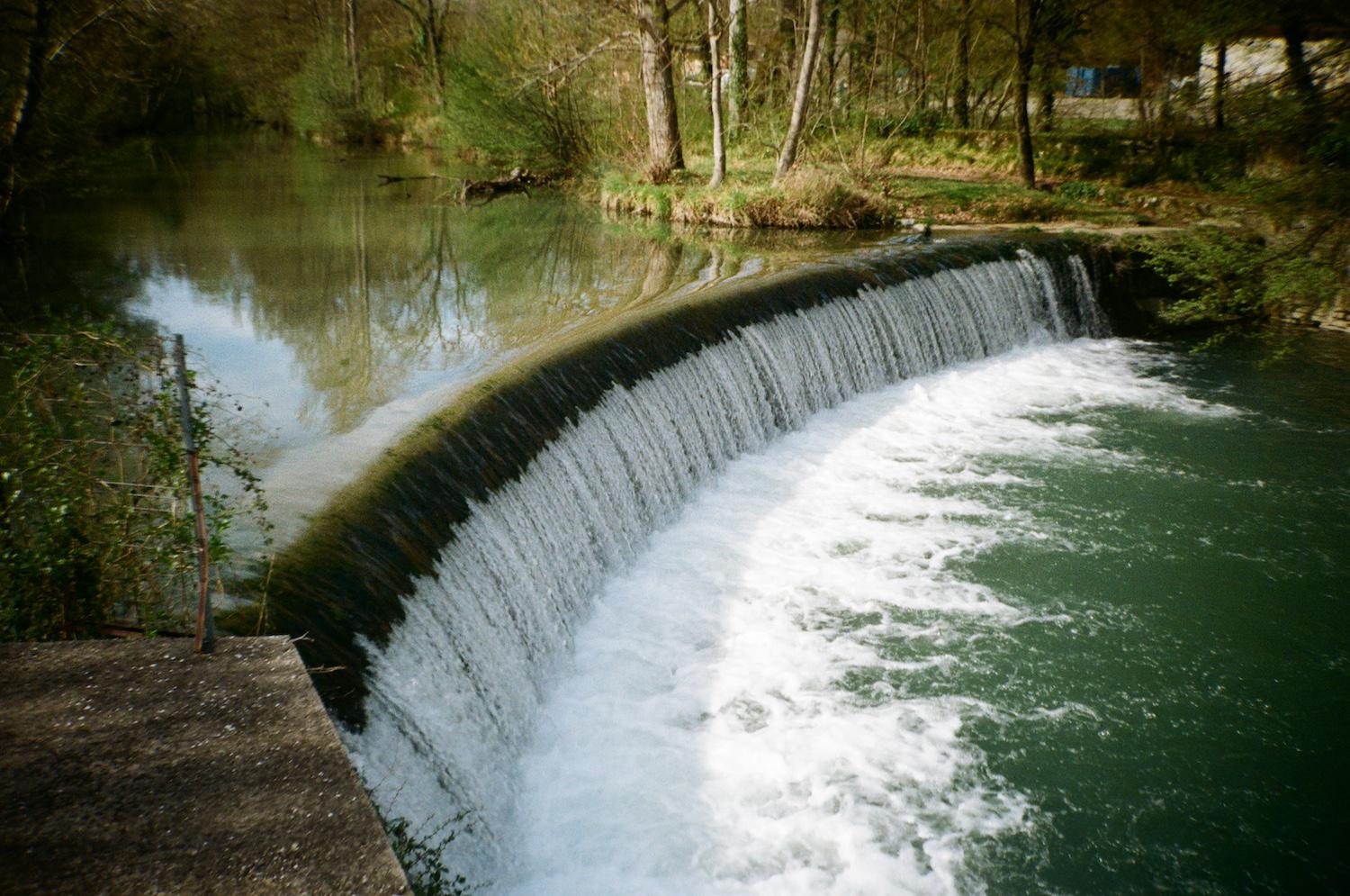 a small, wide waterfall on a river