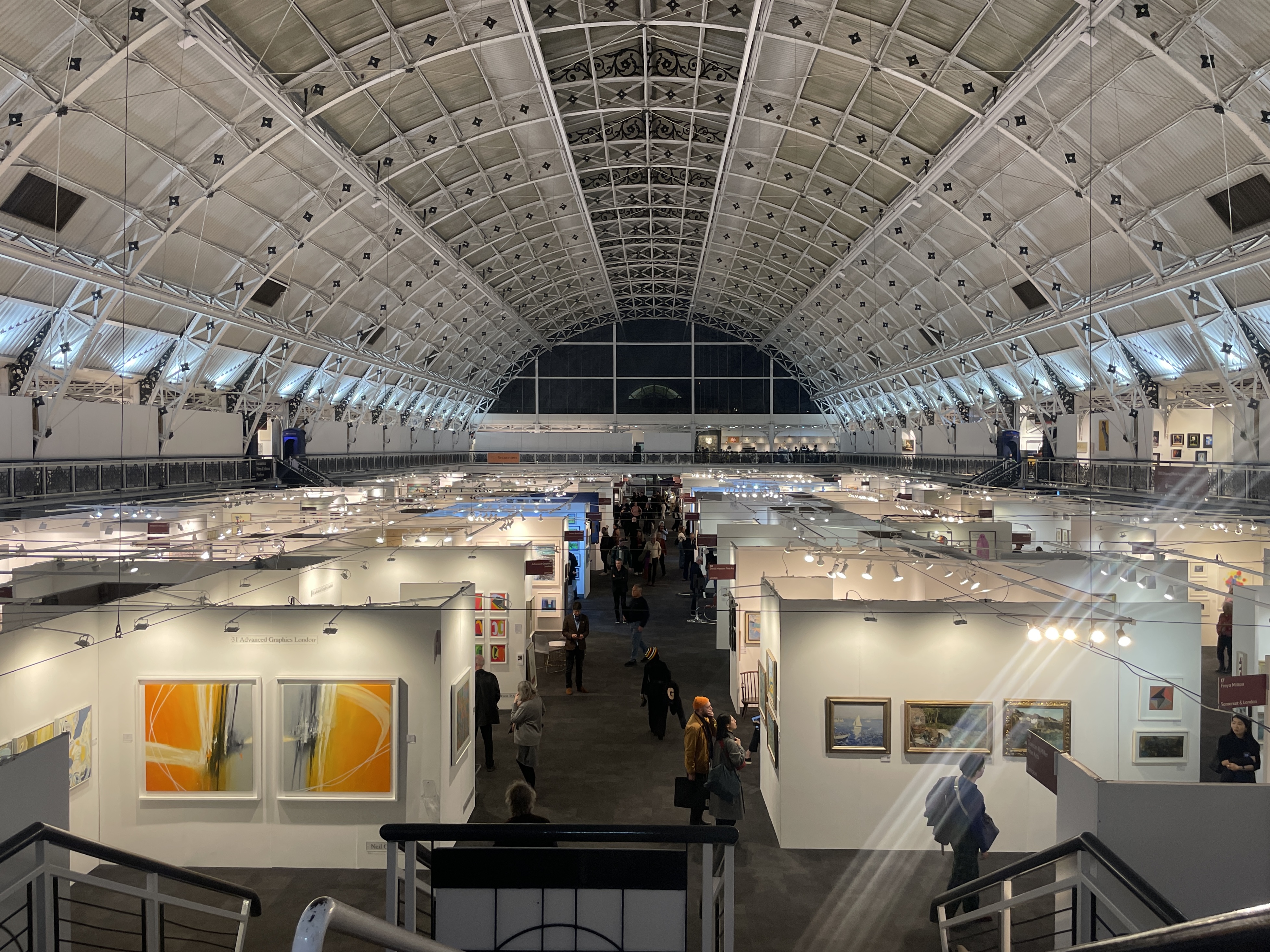 a view of london art fair from upstairs looking down over the tops of booths in the business centre in islington